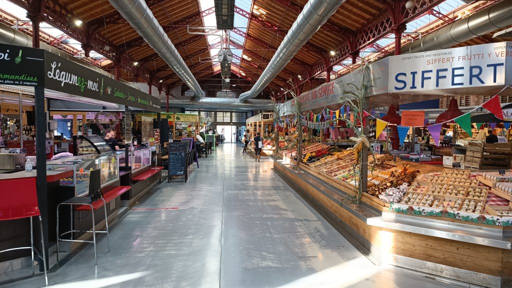 Innenansicht des Marché couvert in Colmar mit Marktständen, Theken und Holzdach
