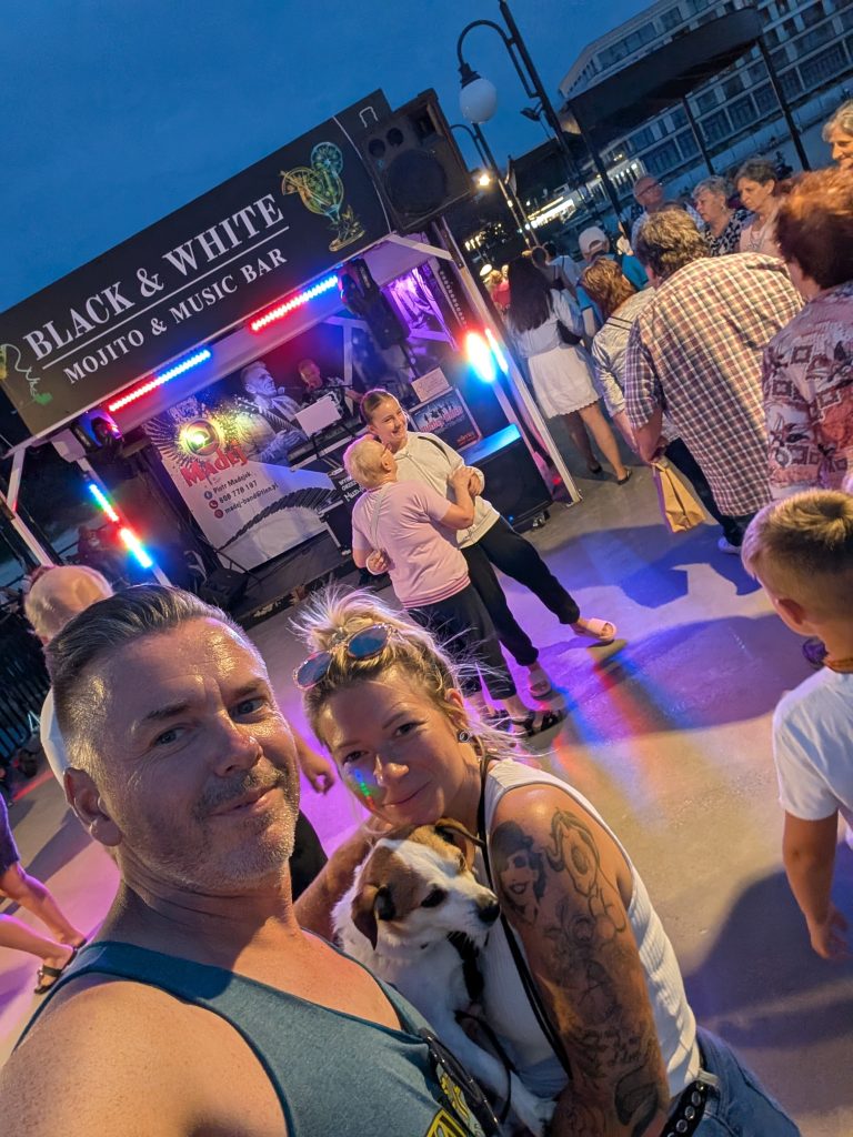 Eva und Robert mit Hund Tyson vor der Black and White Music Bar auf dem Molo von Misdroy am Abend