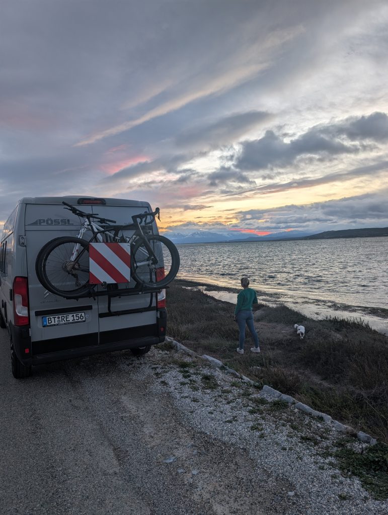 Unser Van mit Fahrradträger am Étang de Leucate in der Abenddämmerung, daneben eine kurze Gassirunde mit Tyson