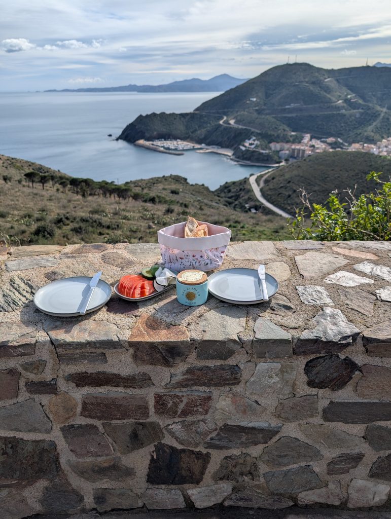 Picknick auf einer Steinmauer auf der französischen Seite des Col de Belitres mit Blick auf die Küste Richtung Spanien