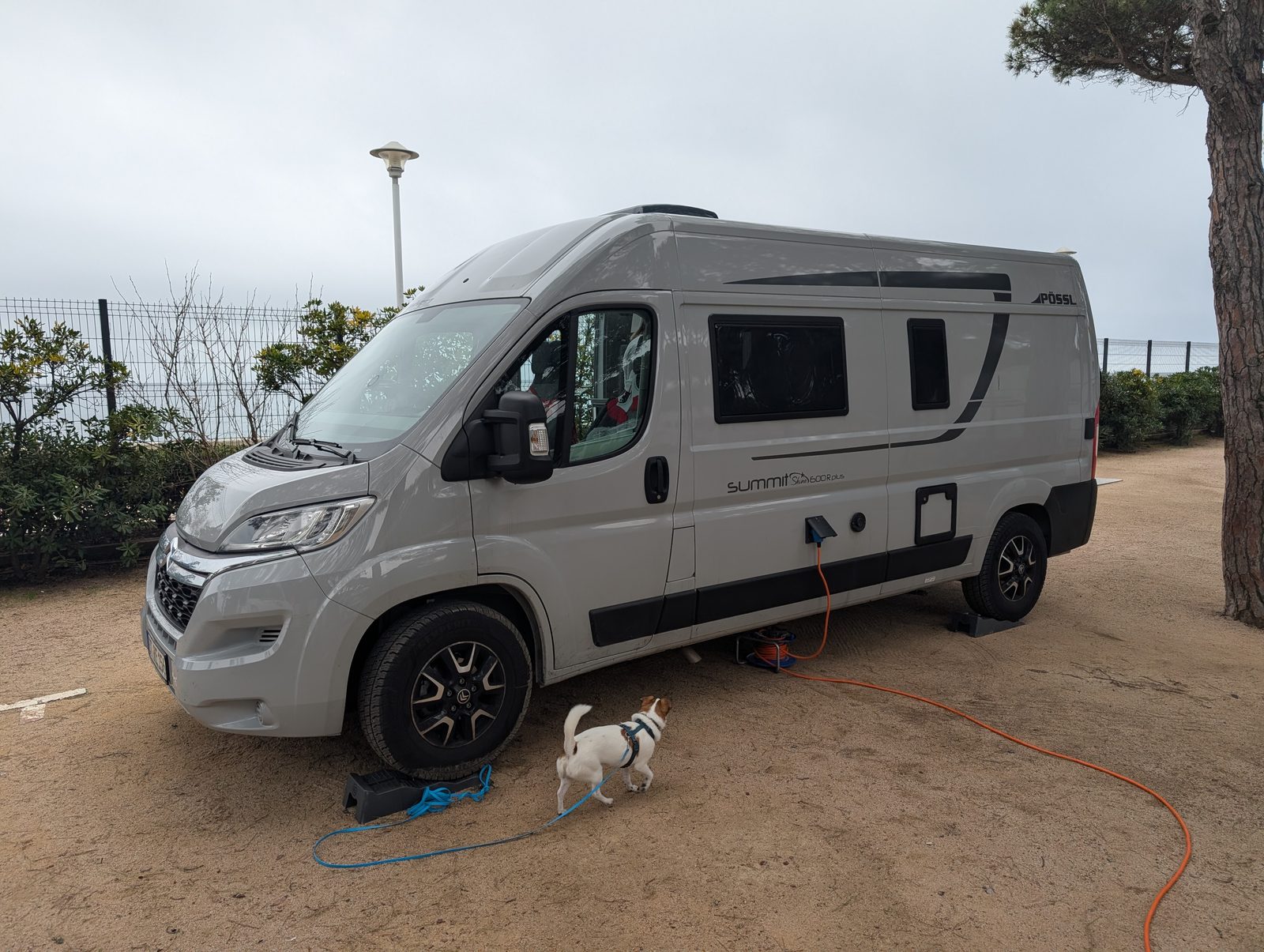 Kastenwagen auf einer Sandparzelle am Campingplatz in Blanes bei bedecktem Himmel