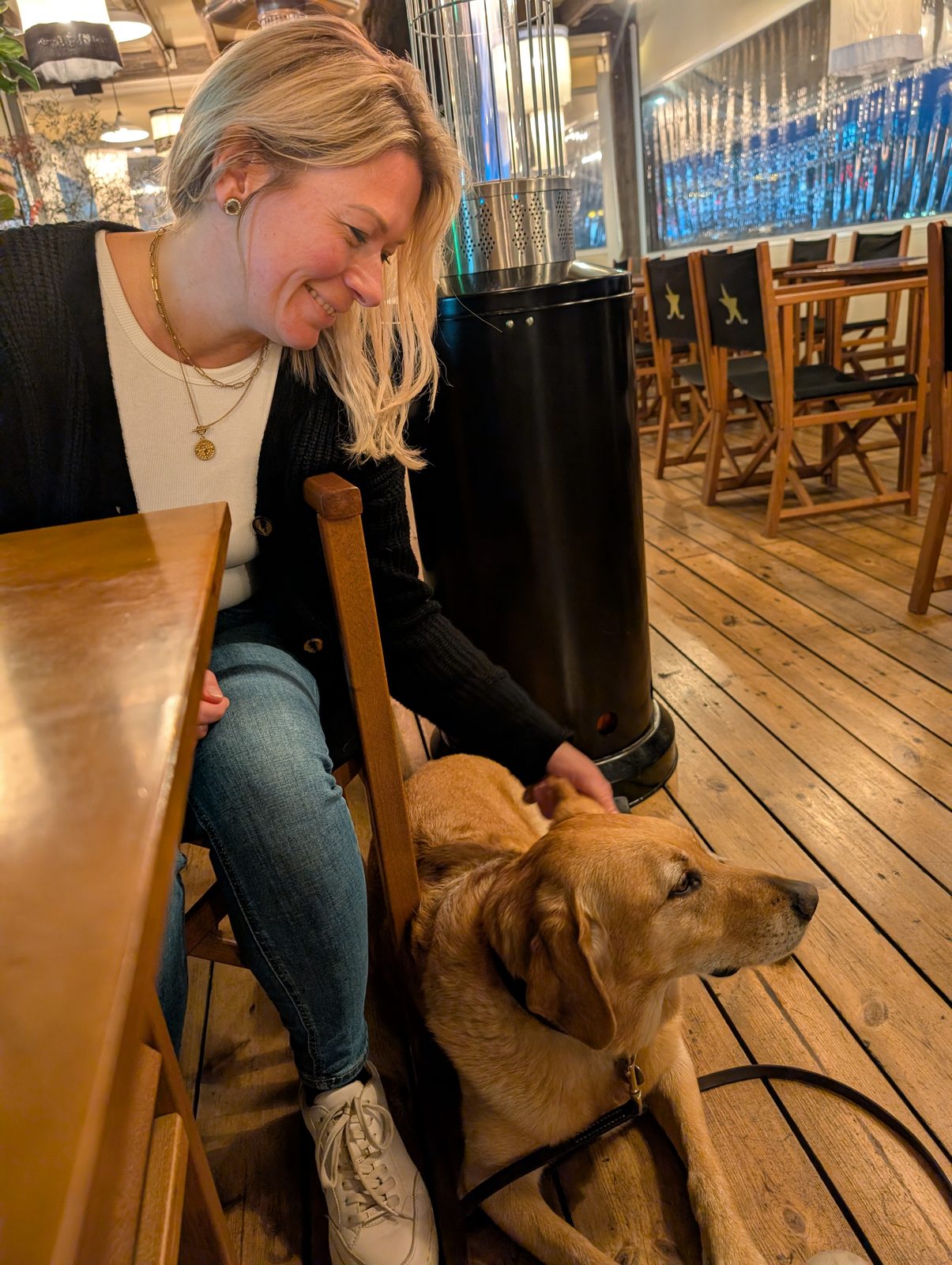 Großer heller Hund liegt neben Eva unter dem Tisch in einem Lokal in Blanes