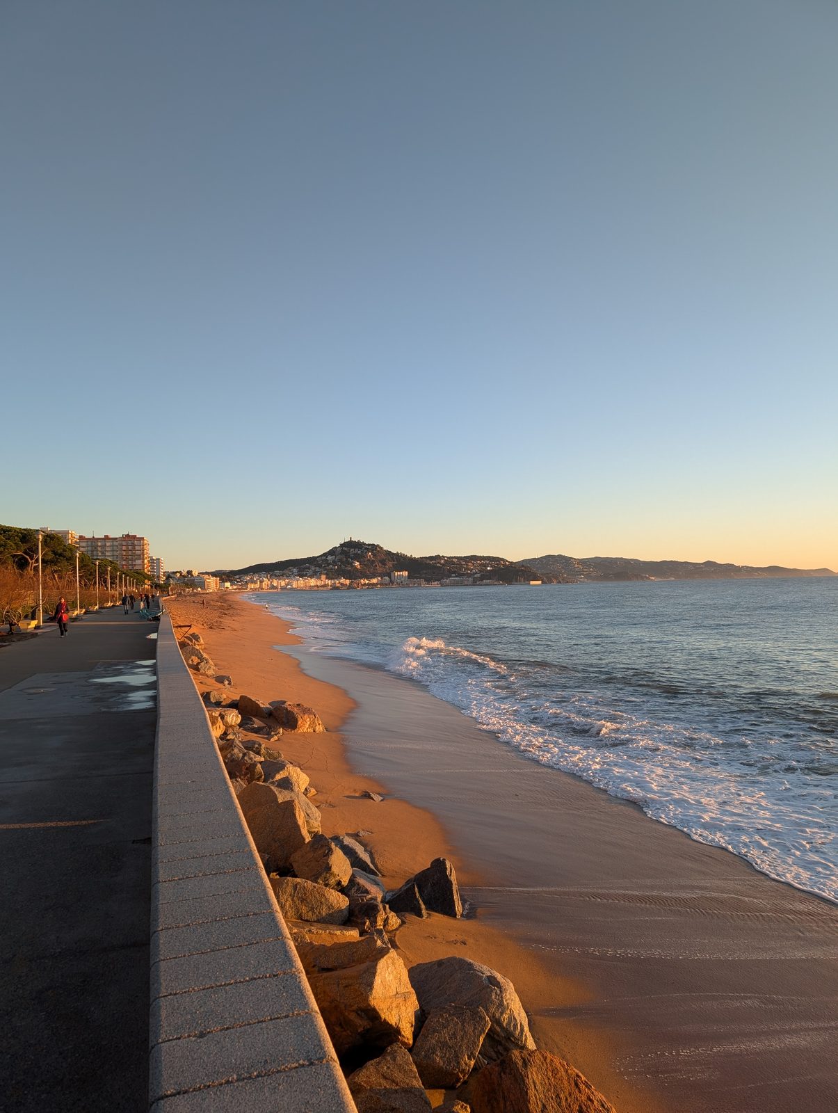 Strandpromenade von Blanes im Morgenlicht, dahinter der Hügel mit dem Castell de Sant Joan