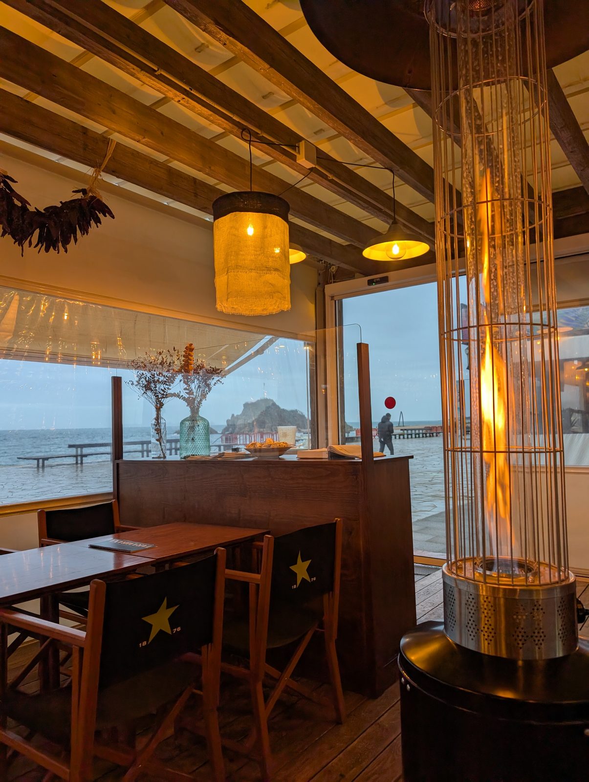 Lokal Ultramarins Tarambana in Blanes am Abend mit Blick durchs Fenster auf den Felsen Sa Palomera
