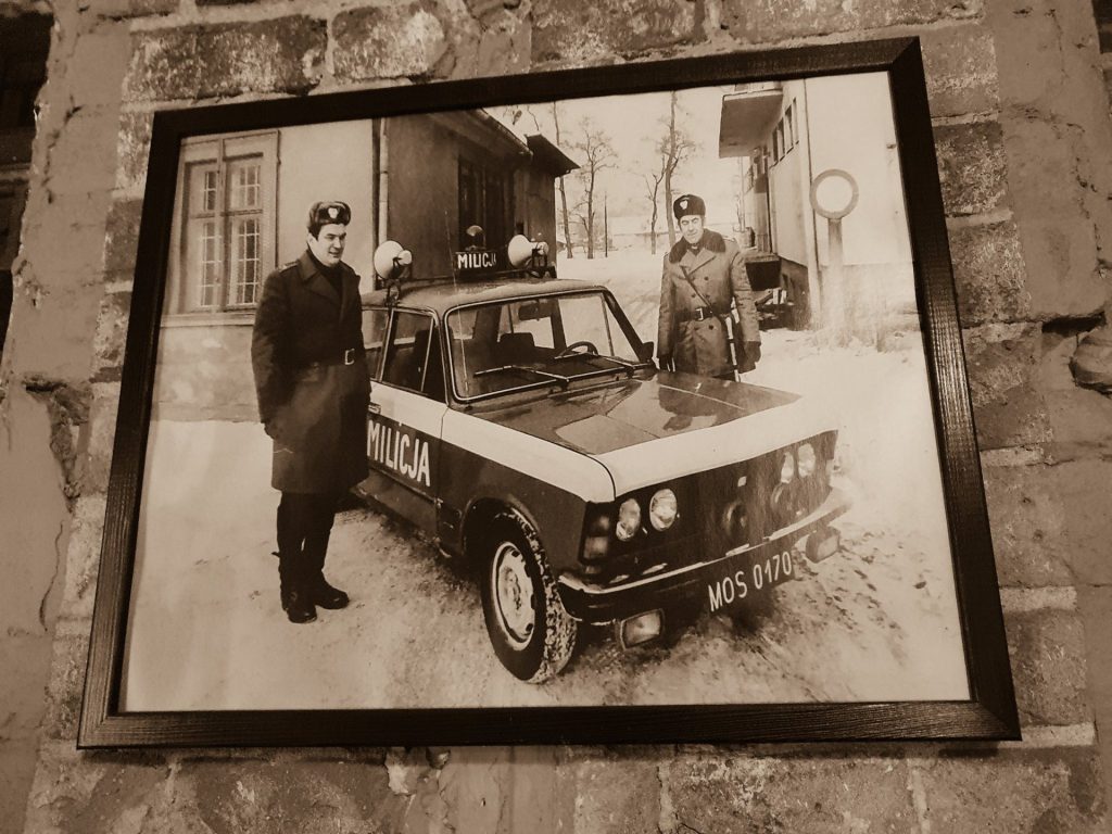 Schwarzweißbild eines Polski Fiat 125p an der Wand einer Bar in Breslau