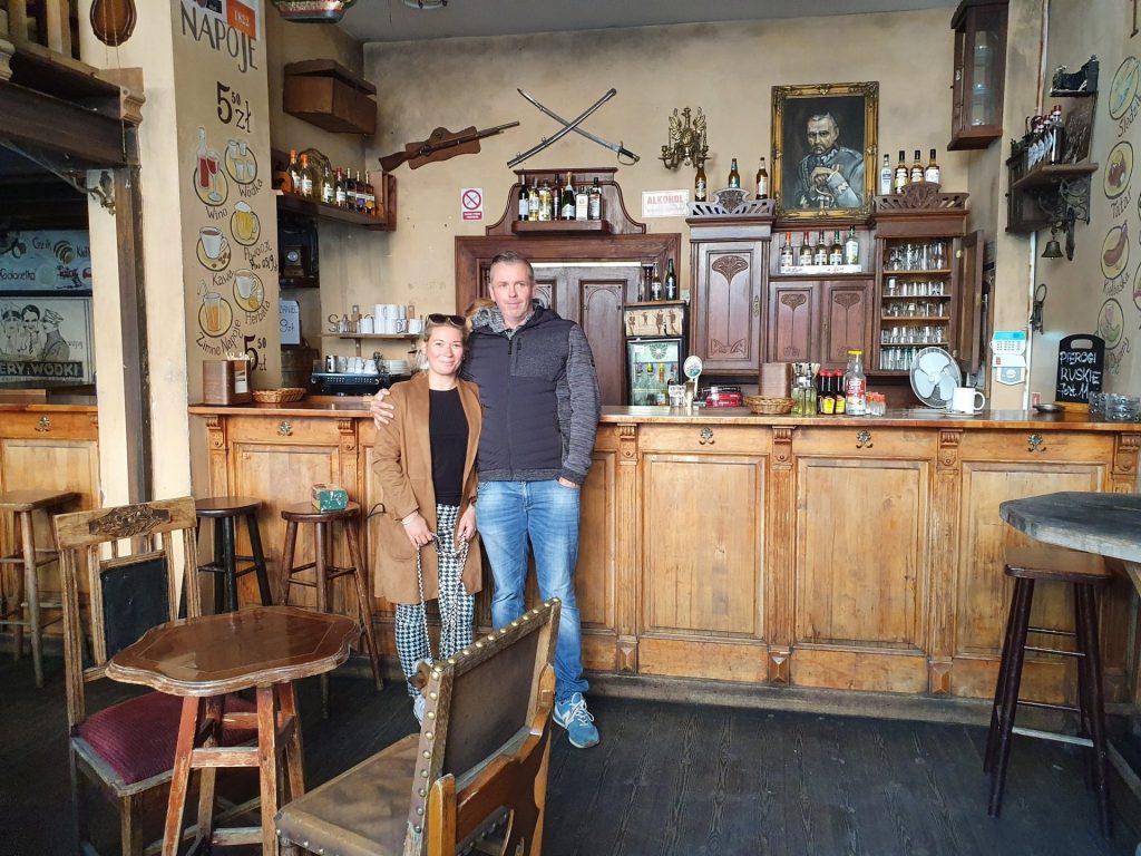 Eva und Robert im Gastraum der Vorkriegskneipe Przedwojenna in Breslau mit dunkler Holzeinrichtung
