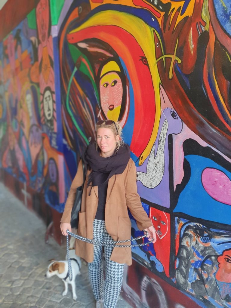 Eva vor einem großflächigen bunten Wandbild in einer Breslauer Gasse