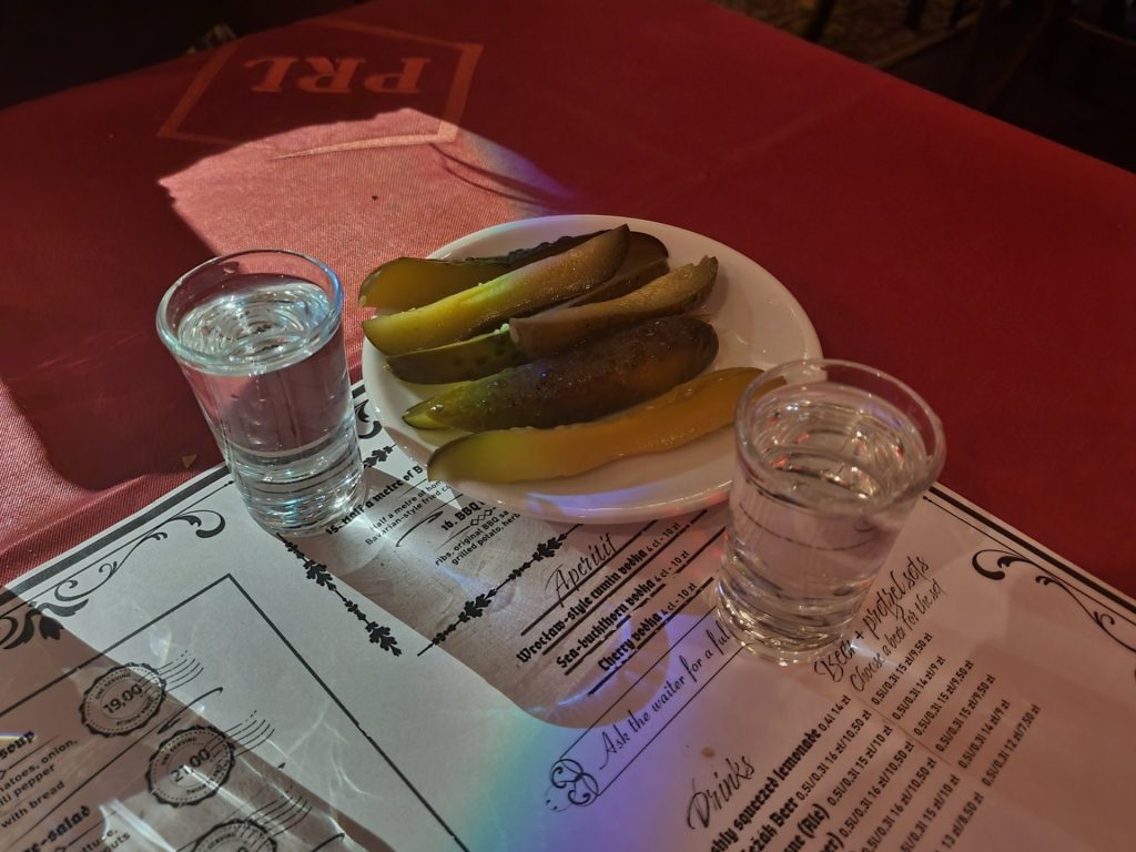 Ein Glas Wodka mit sauren Gurken auf einem Tisch in einer Breslauer Bar