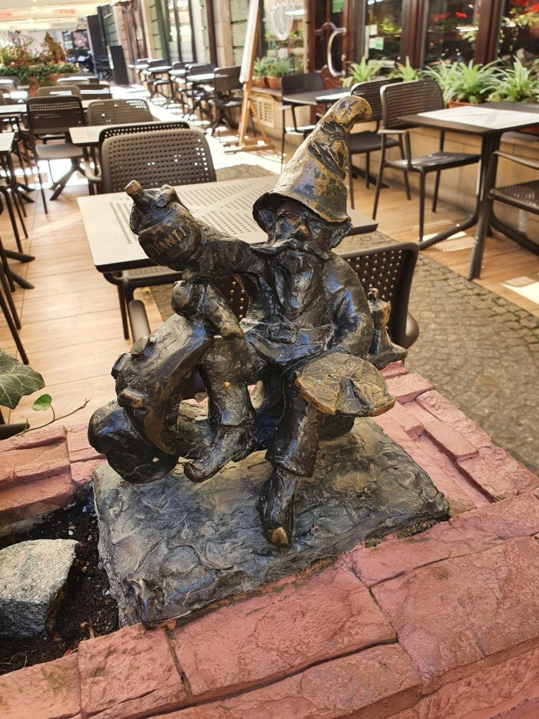 Mehrere Breslauer Zwerge als Bronzefiguren in einer Gruppe auf dem Pflaster