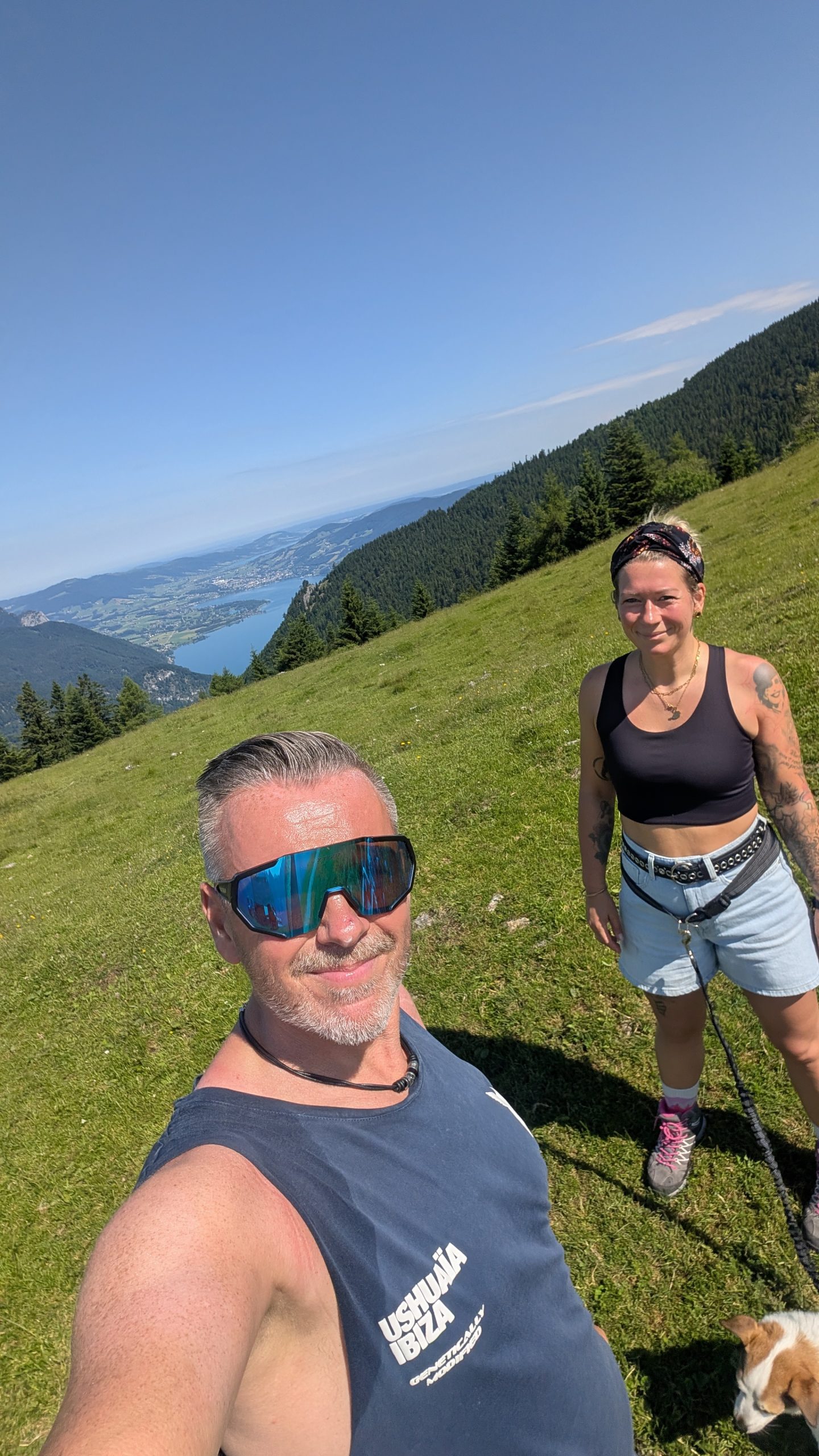 Eva und Robert auf einer Almwiese mit Seeblick in den österreichischen Alpen