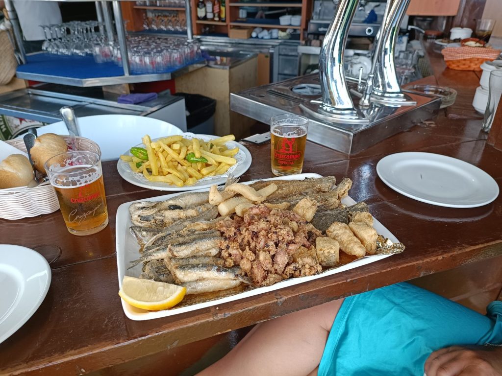 Teller mit frittiertem Fisch, Zitrone und Pommes, dazu Bier, in Isla Cristina