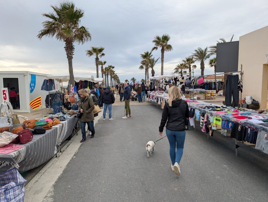 Sonntagsmarkt an der Strandpromenade von Le Barcarès, Eva mit Tyson zwischen den Ständen