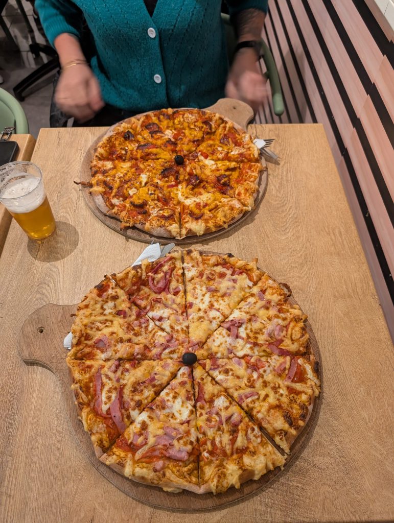 Zwei Pizzen und ein Bier auf dem Tisch in der Pizzeria Tic-Tac in Le Barcarès