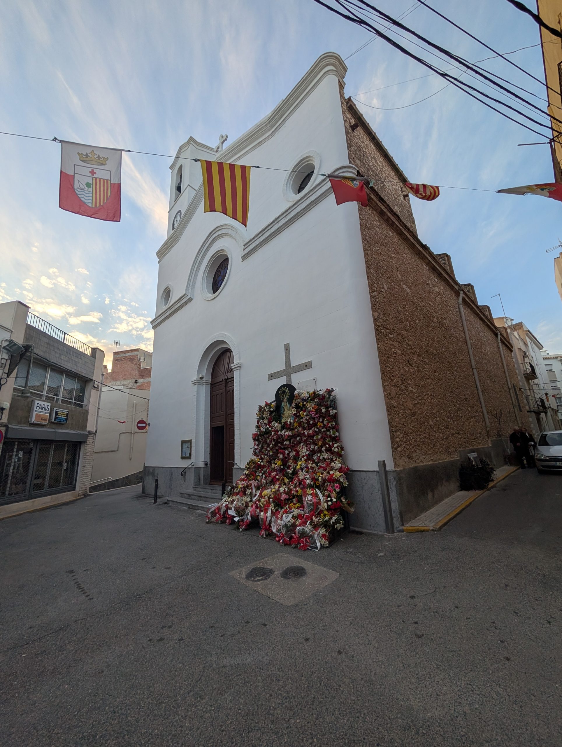 Weiße Kirche mit Blumenteppich vor dem Eingang, katalanische Fahnen