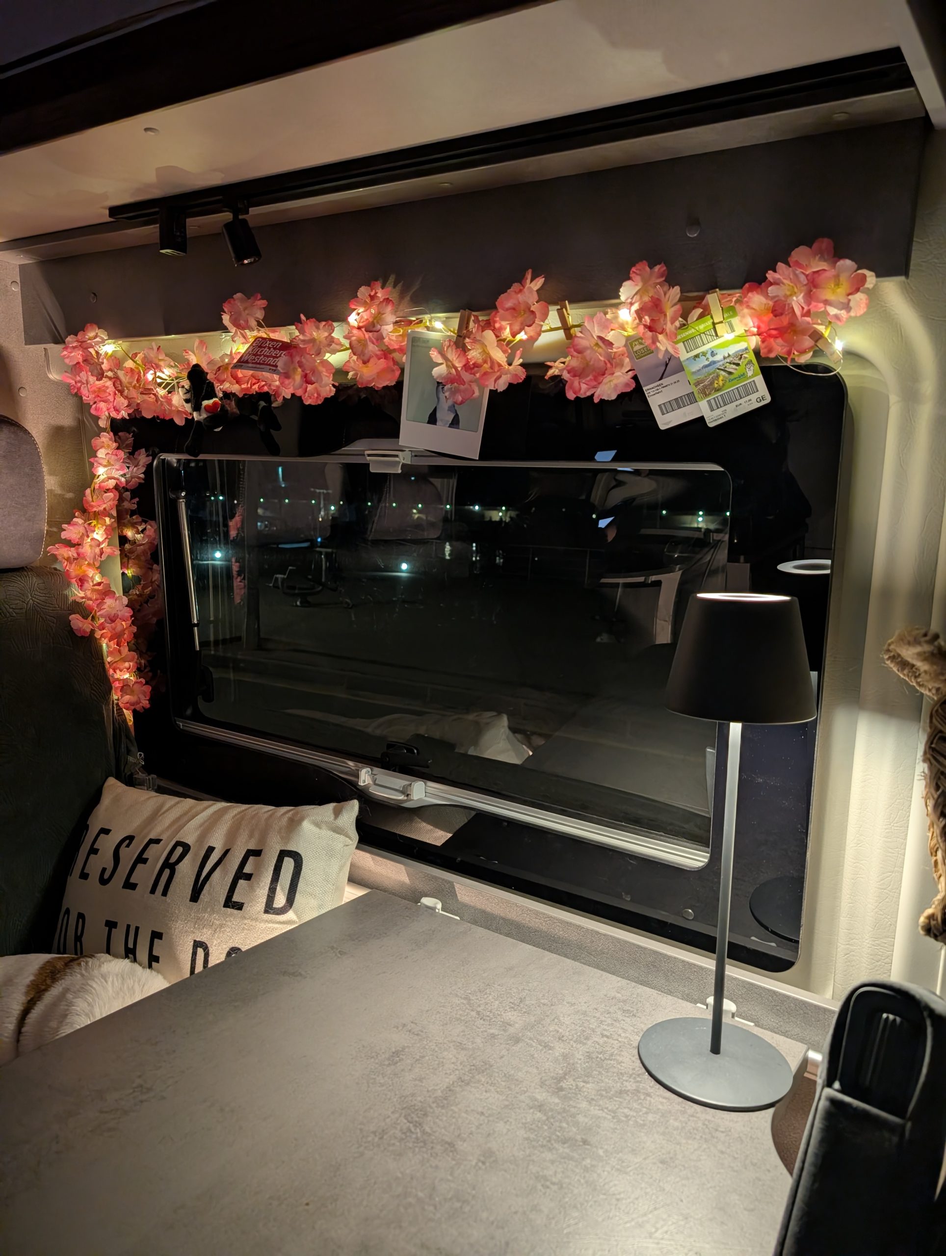 Camper-Innenraum mit Blumengirlande und „Reserved“-Kissen für Tyson