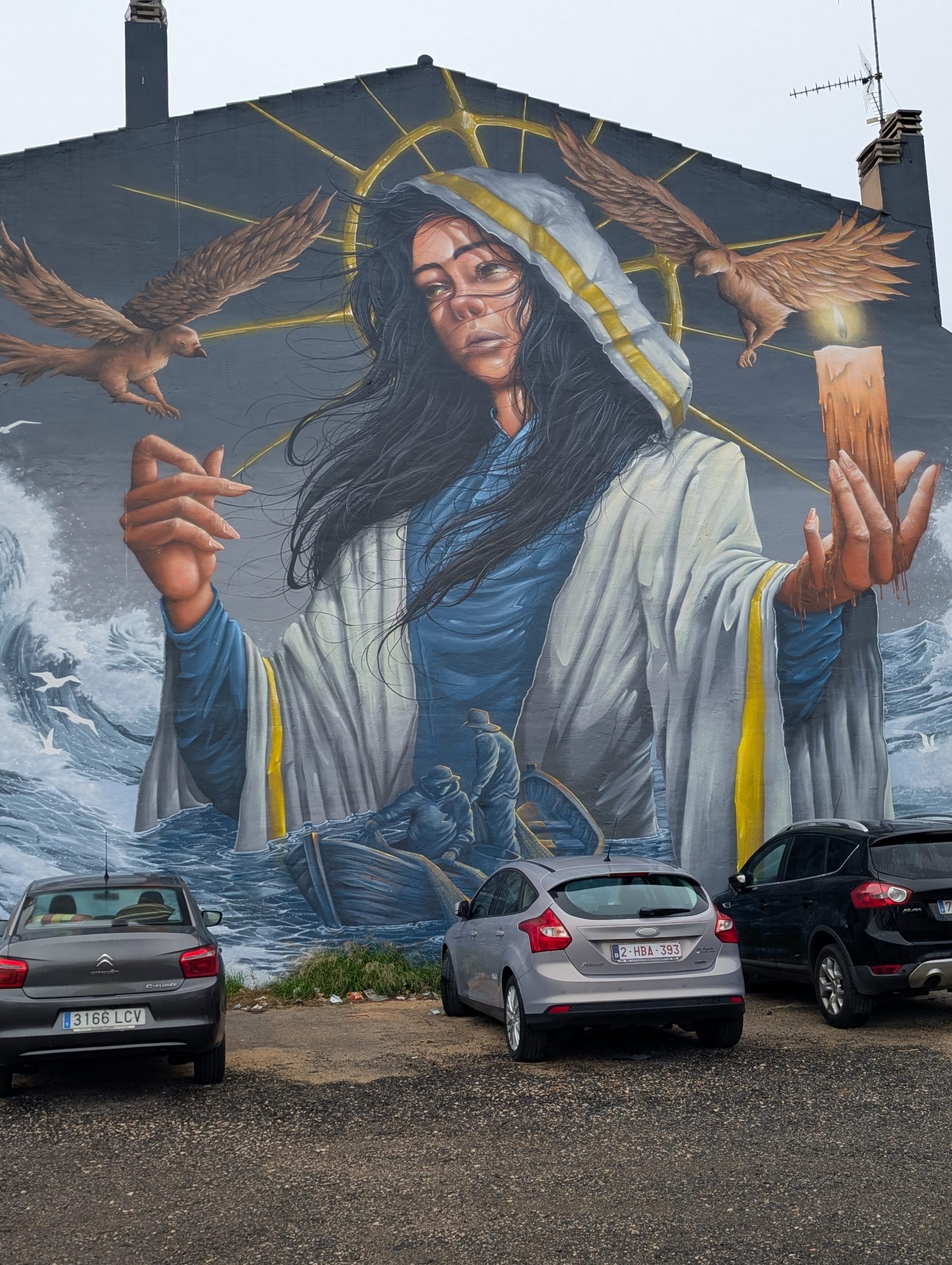 Wandbild der Mare de Déu de la Candelera mit Kerze über stürmischem Meer
