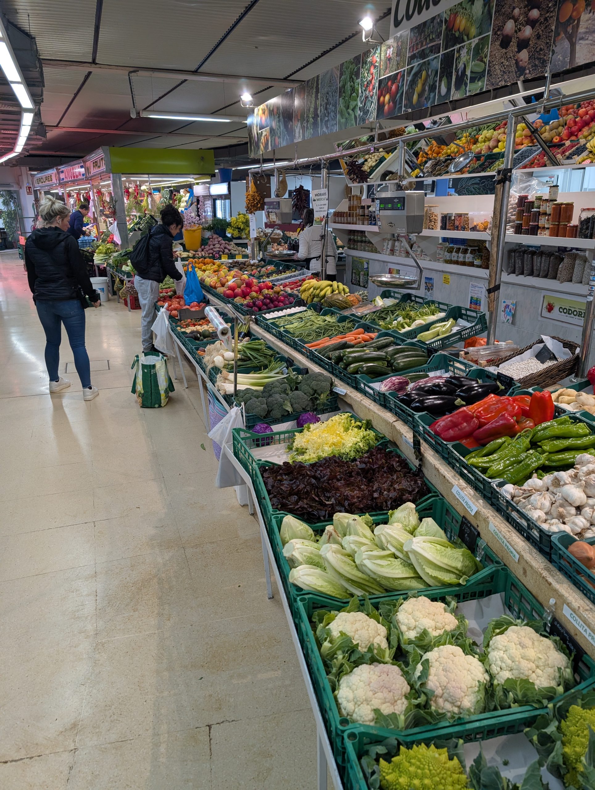 Eva von hinten zwischen langen Obst- und Gemüsereihen im Markt