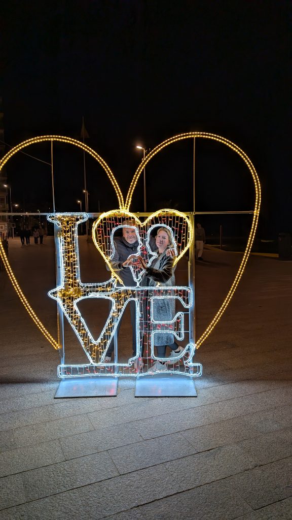 Eva und Robert im großen Lichterherz mit dem Schriftzug LOVE an der Promenade von Calp bei Nacht