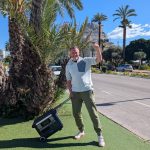 Robert trägt die leere Powerstation zwischen Palmen in Calp