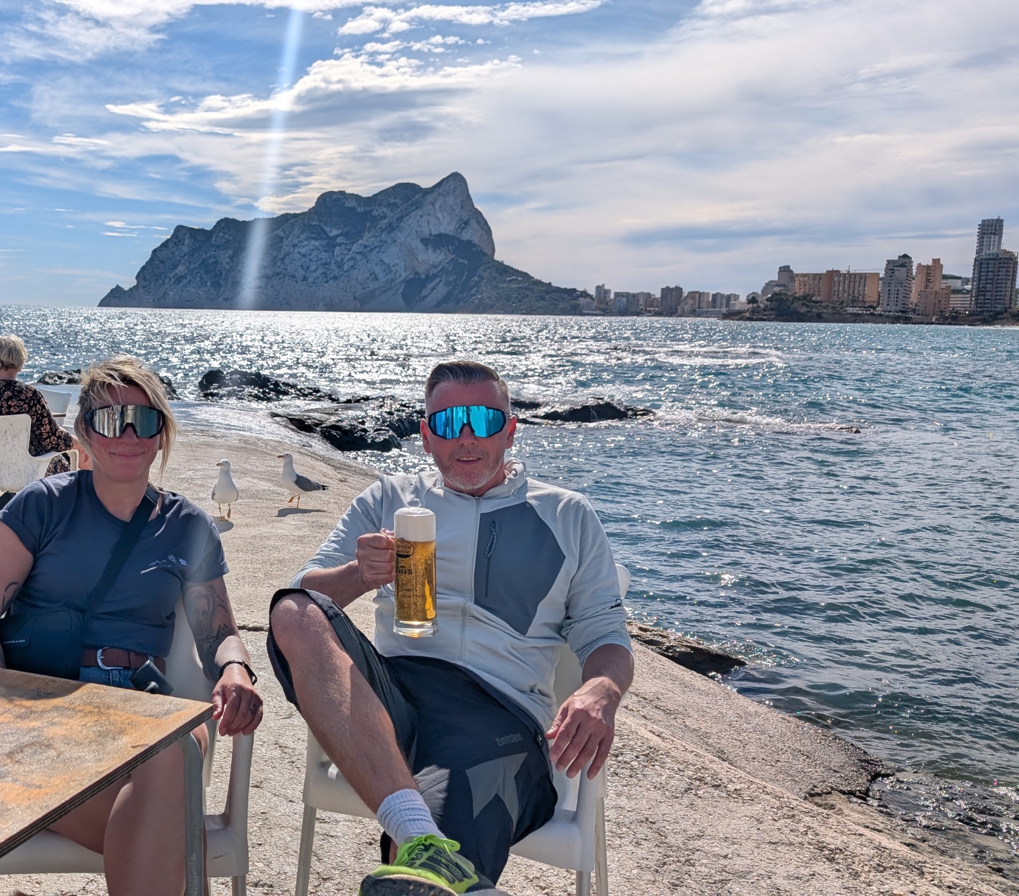 Eva und Robert beim Bier in einer Bucht, hinten der Peñón d'Ifach